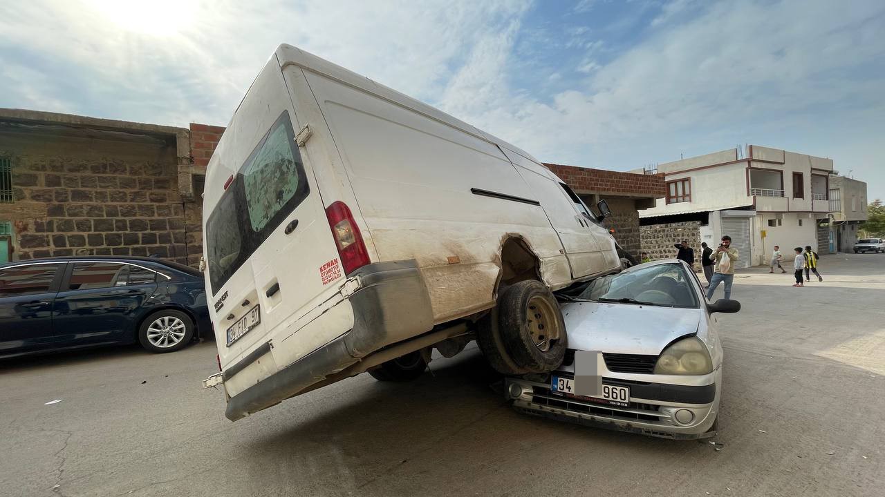 Minibüs park halindeki otomobilin üstüne çıktı