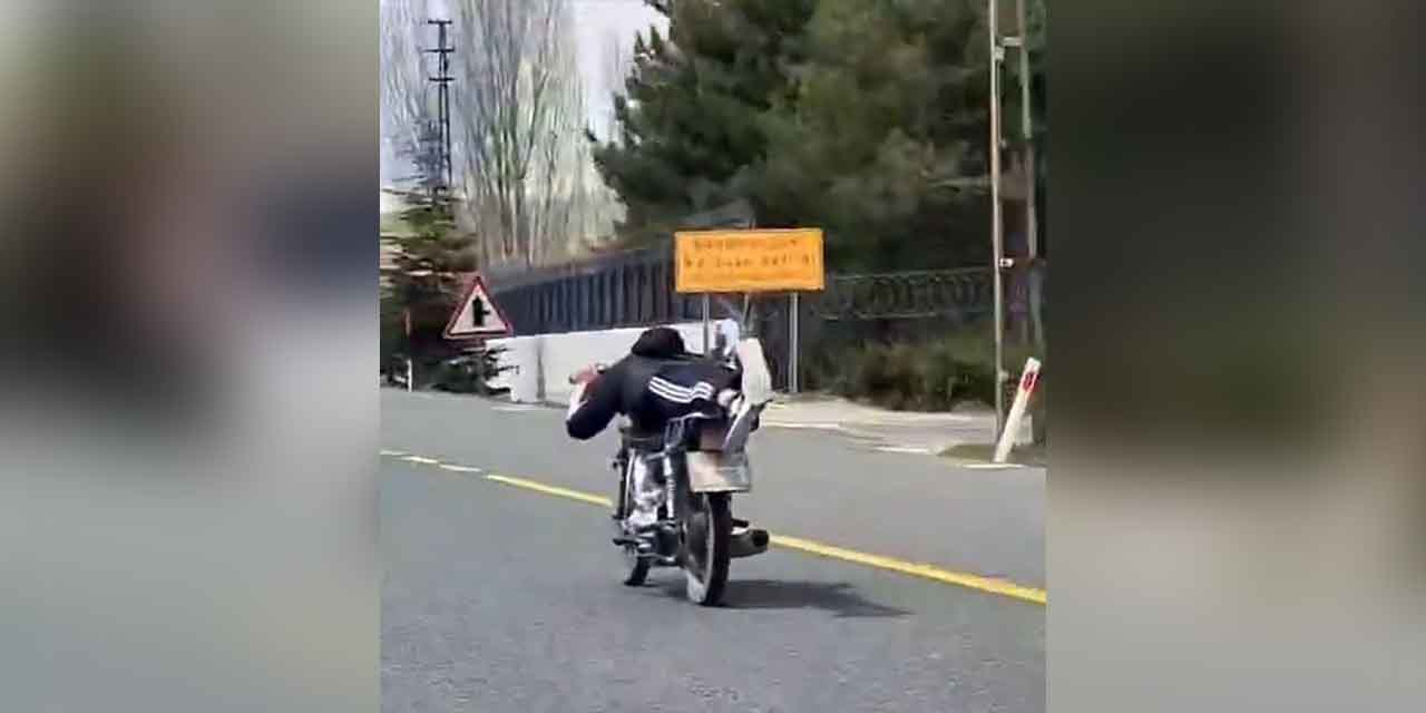 Sürücü, canını hiçe sayarak motosikleti uzanarak seyretti!
