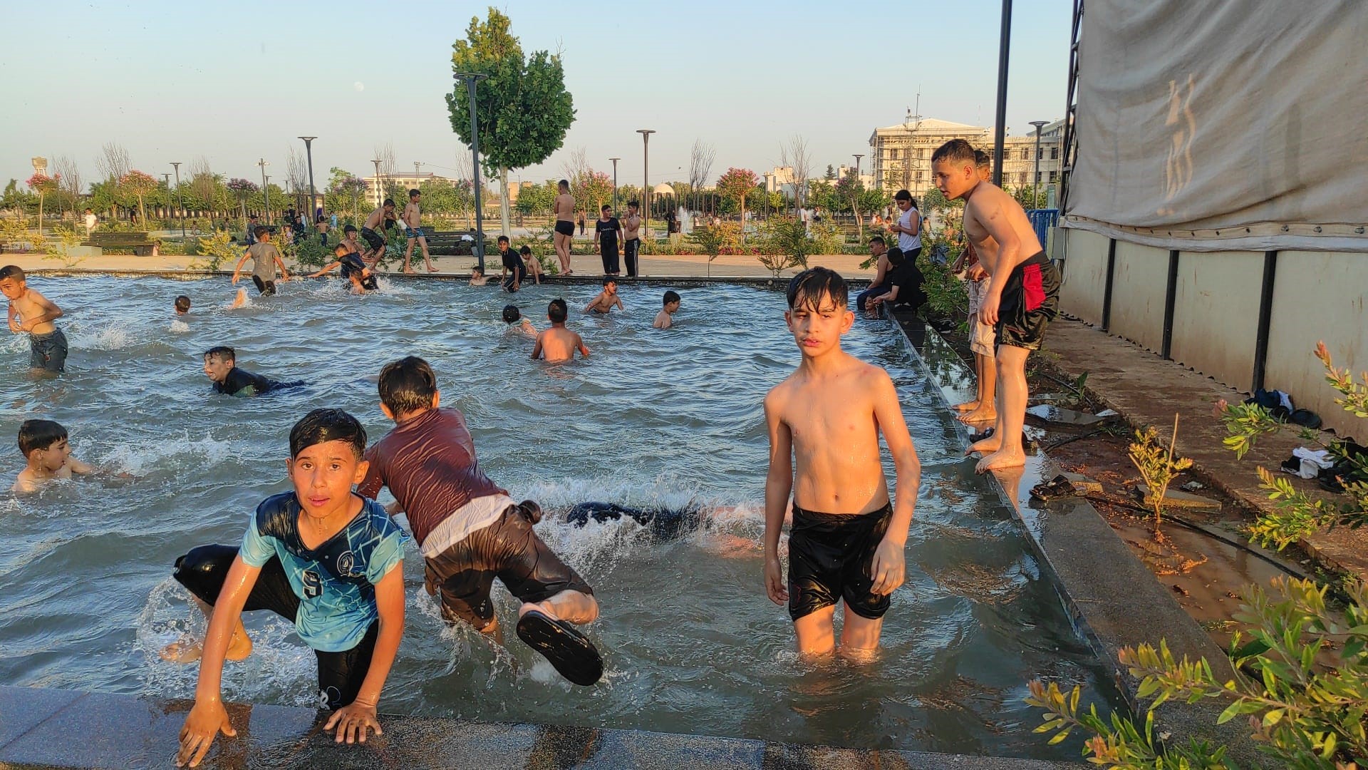 Sıcaktan bunalan çocuklar süs havuzunda serinledi