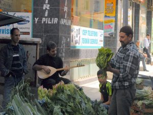 Hem saz çalıyor hem sebze satıyor