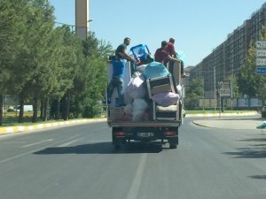 Kamyonet kasasında eşyalara tutunan işçiler görenleri şaşırttı