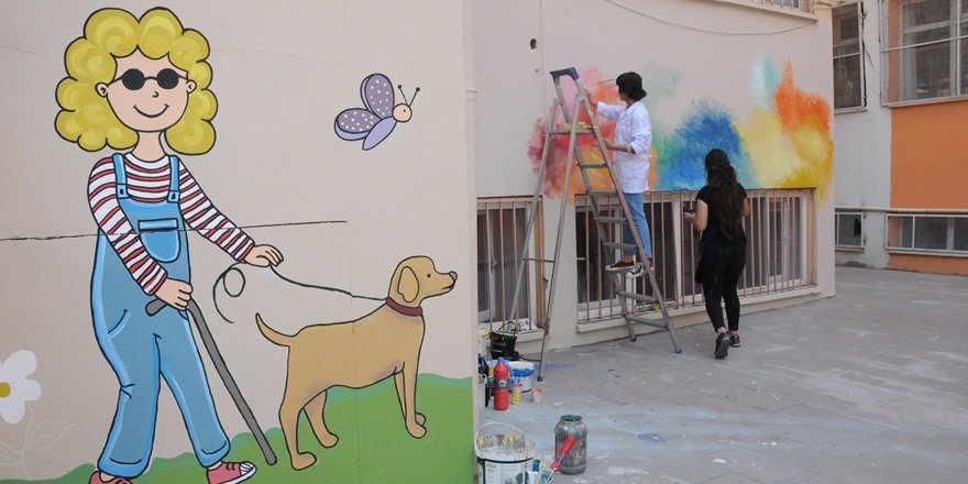 Fırça elde okul duvarlarını renklendiren öğretmenler